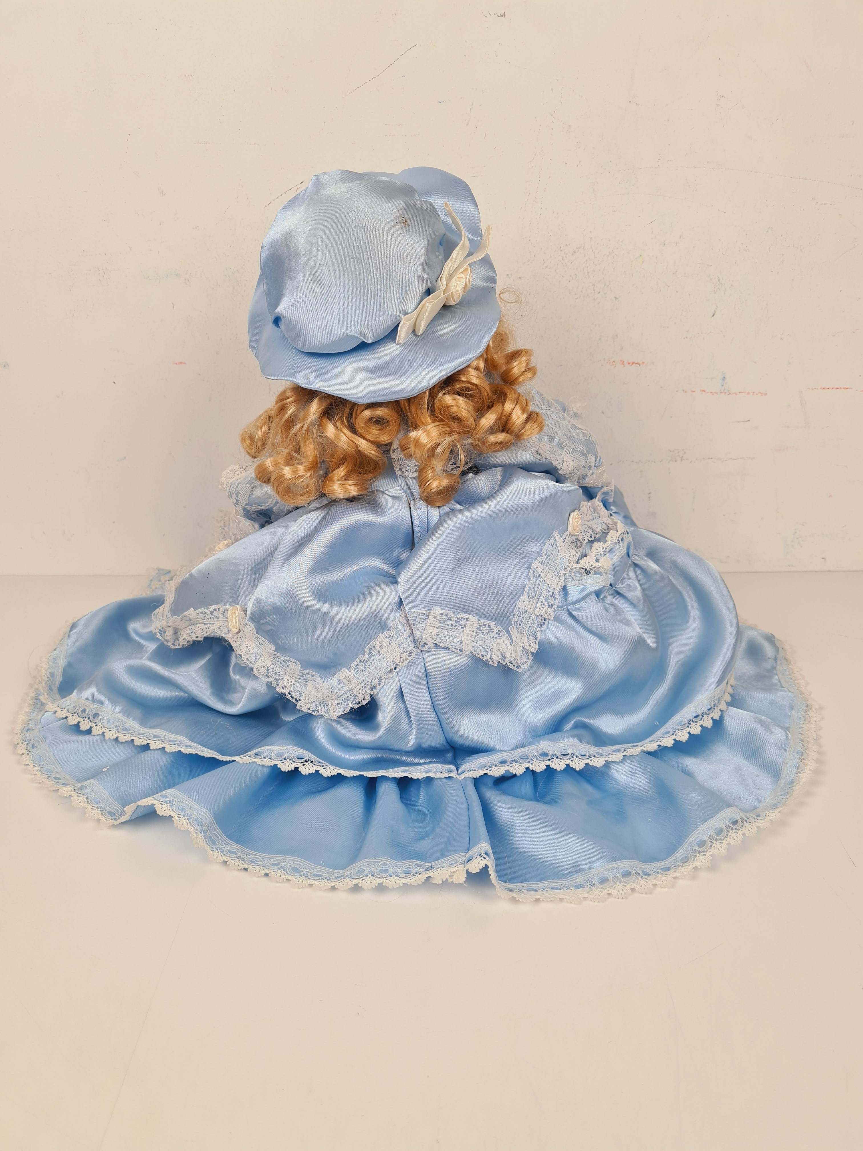 Voir photo 3 de Poupée - Poupée en porcelaine sur coussin avec une robe bleu - 33 cm Poupée - Poupée en porcelaine sur coussin avec une robe bleu - 33 cm Bon état - Vue 3 -